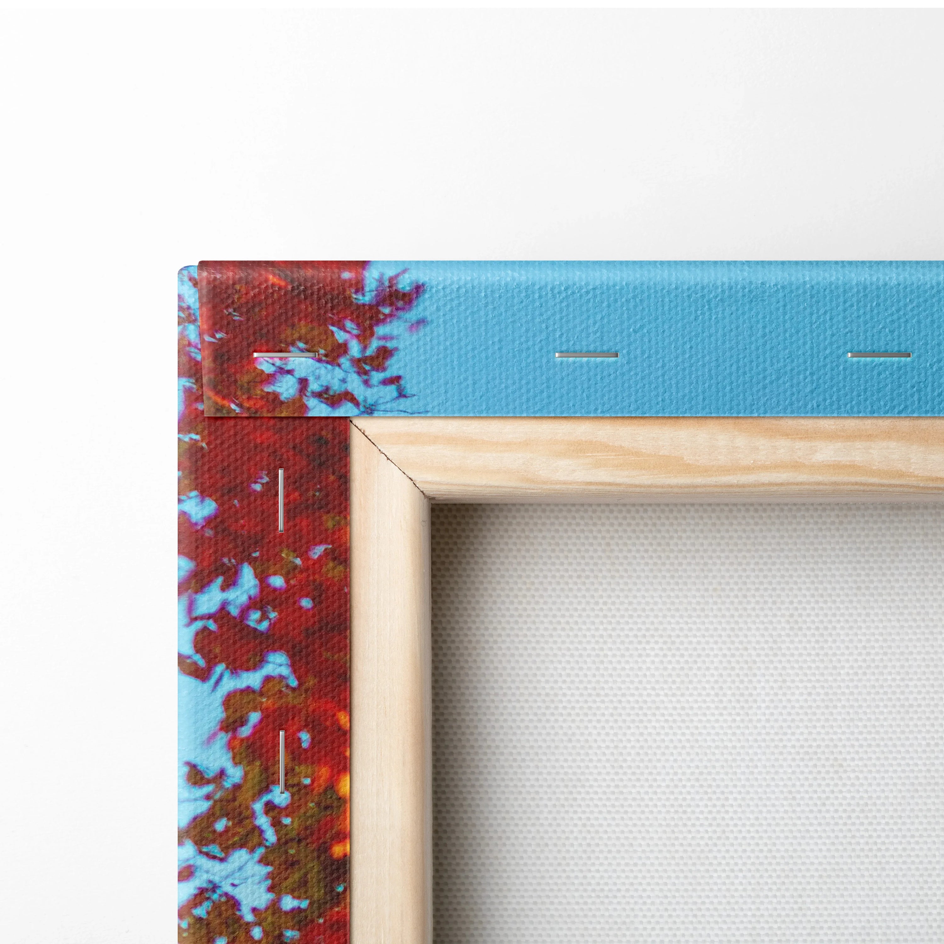 Corner detail of vibrant autumn landscape canvas art print with natural wood frame and sky blue background.