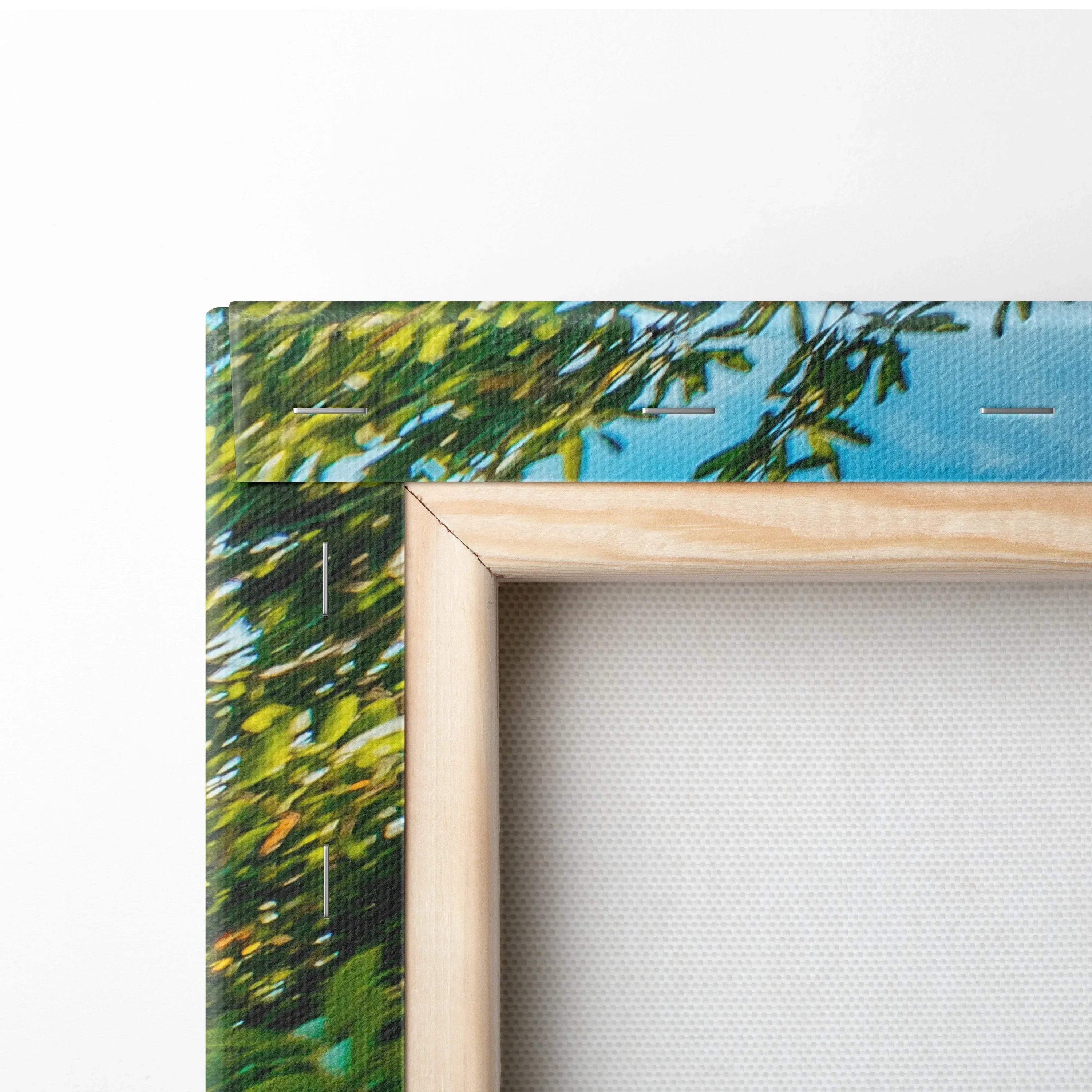Close-up of wooden-framed canvas wall art showing vibrant green leaves and blue sky background.