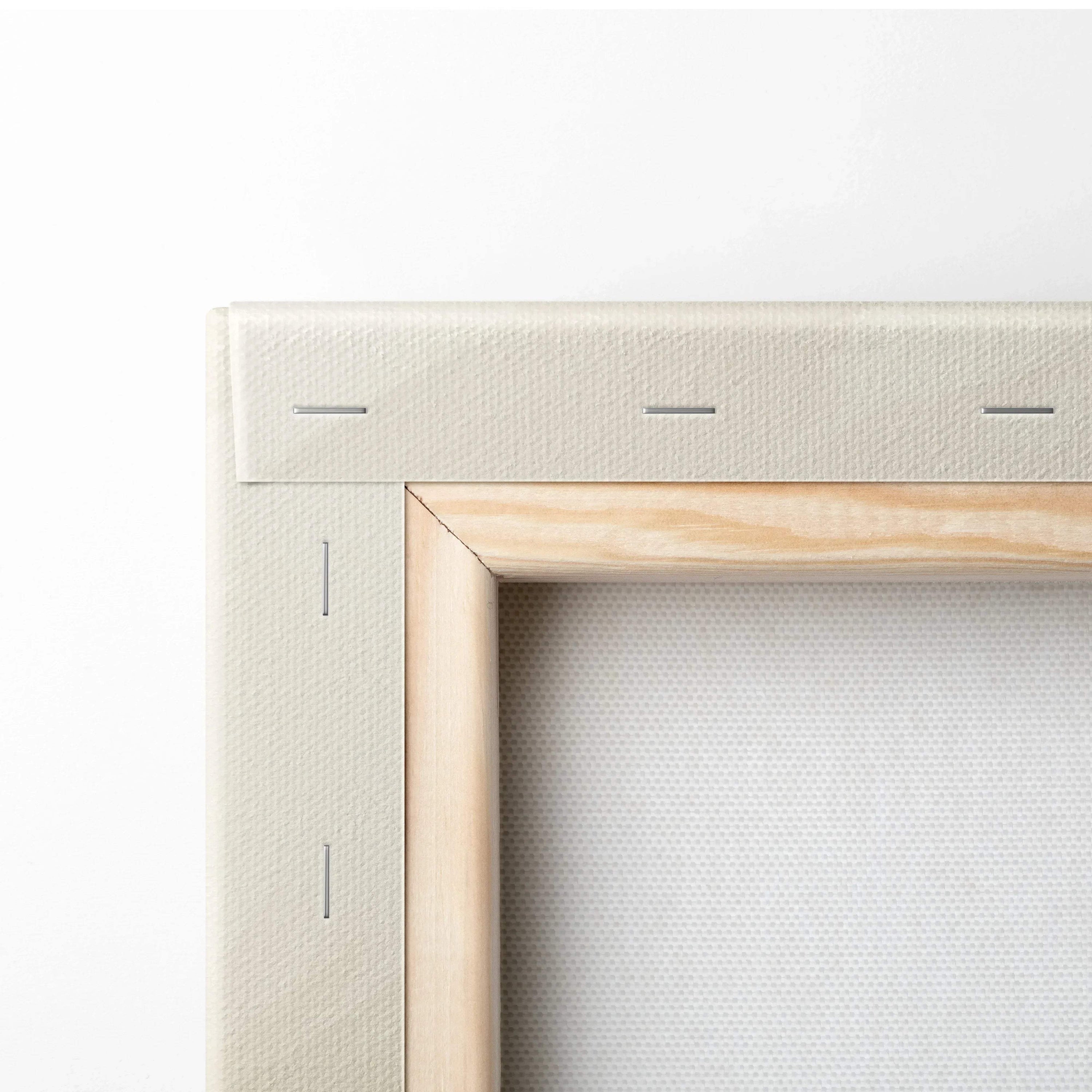 Close-up of wooden frame and stapled edge of blank white canvas for wall art preparation.