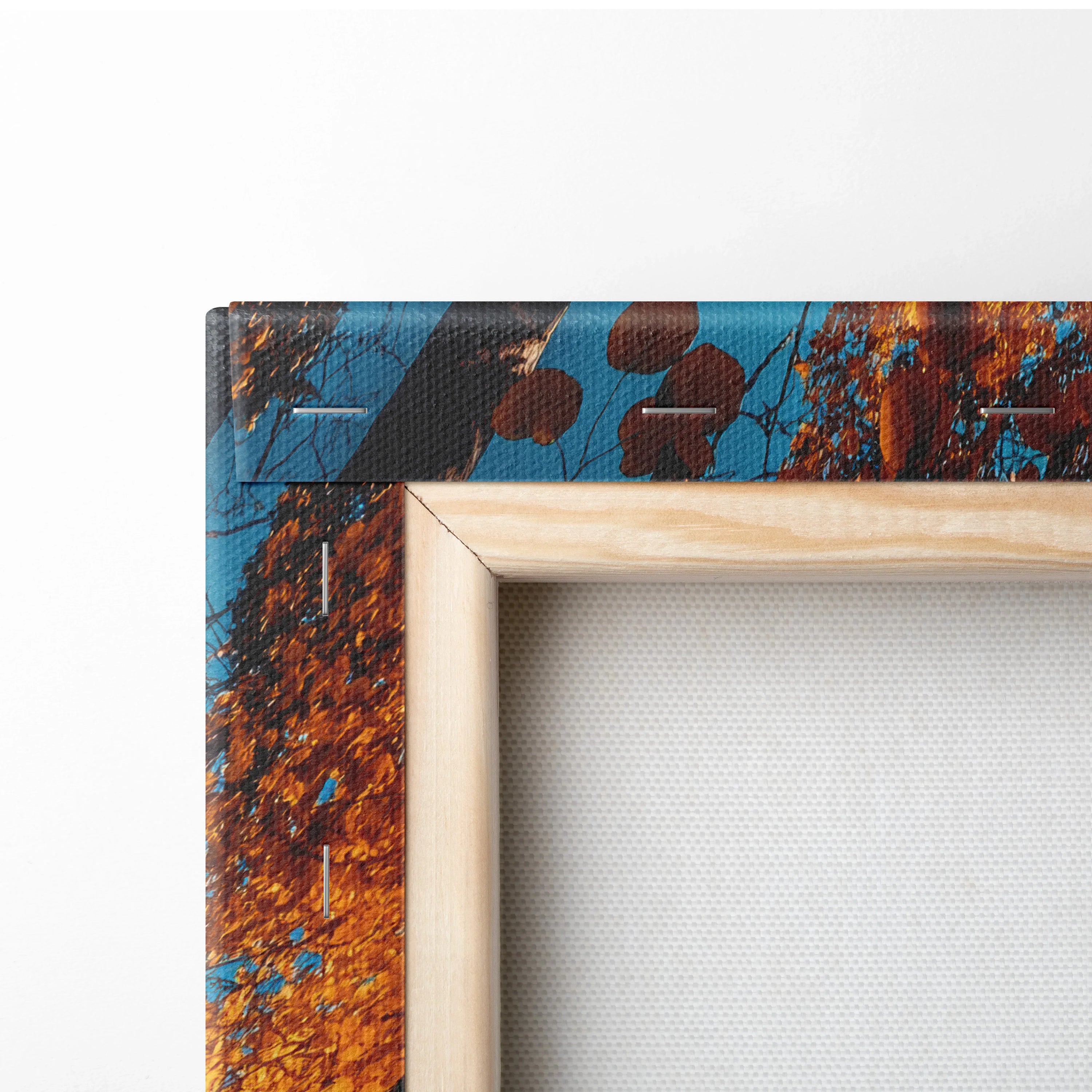 Close-up of vibrant autumn nature canvas art with rich orange and blue hues, wooden frame edge visible.