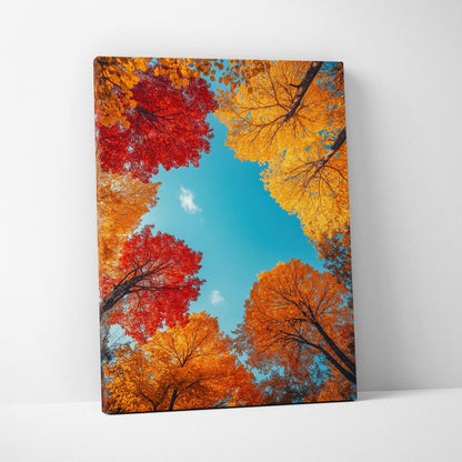 Vertical canvas wall art featuring vibrant autumn trees with red, orange, and yellow leaves against a bright blue sky.
