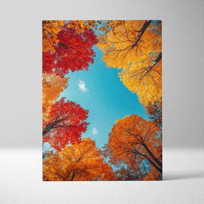 Vertical canvas wall art featuring vibrant autumn leaves in red, orange, and yellow against a bright blue sky.