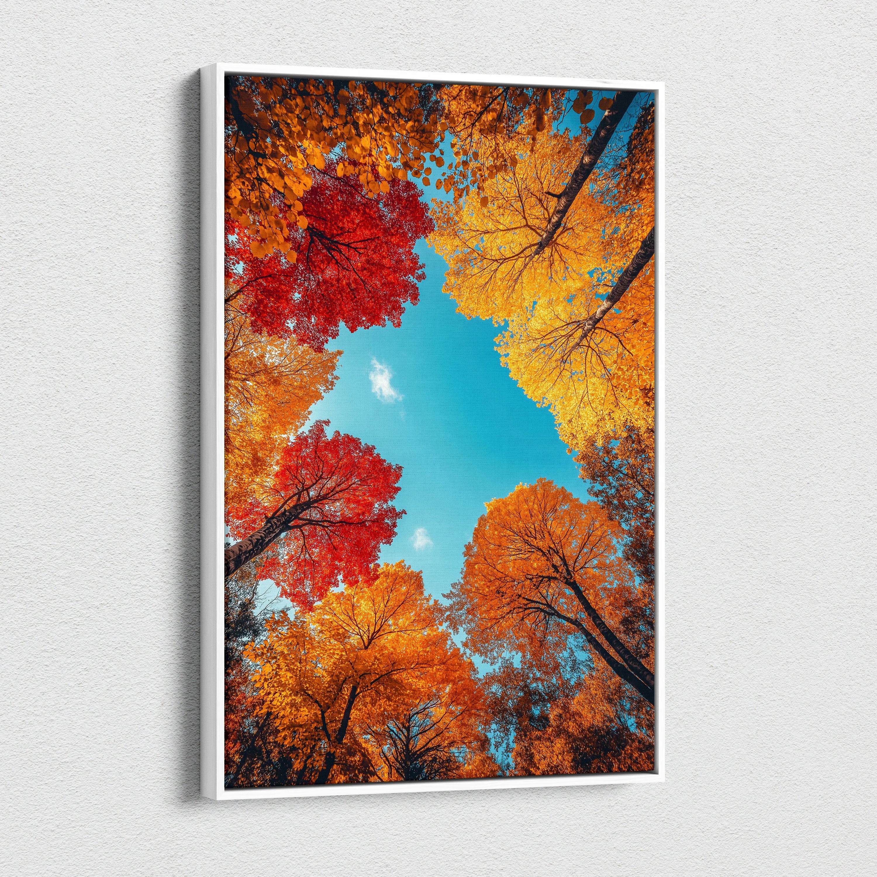 Vertical canvas wall art featuring vibrant red, orange, and yellow autumn leaves against a bright blue sky.