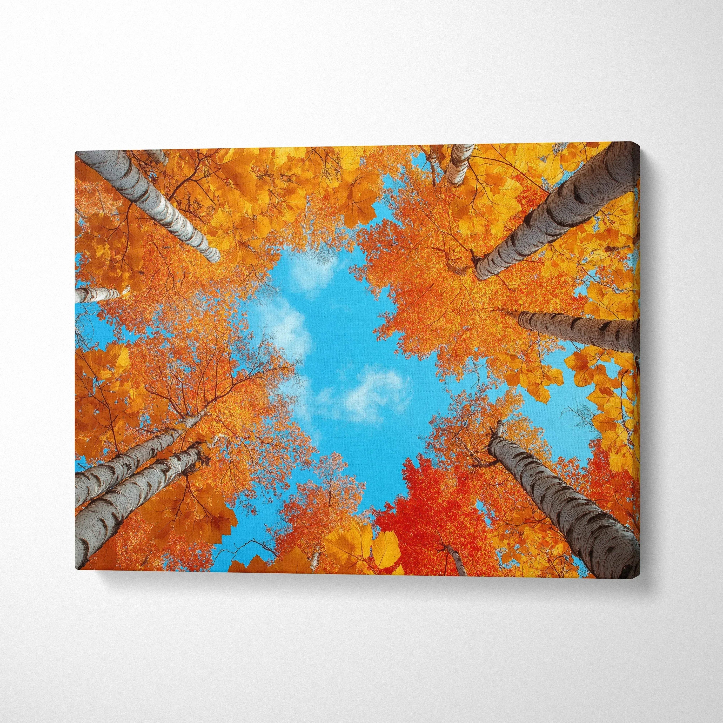 Canvas wall art of golden and orange autumn foliage viewed upward against a bright blue sky.