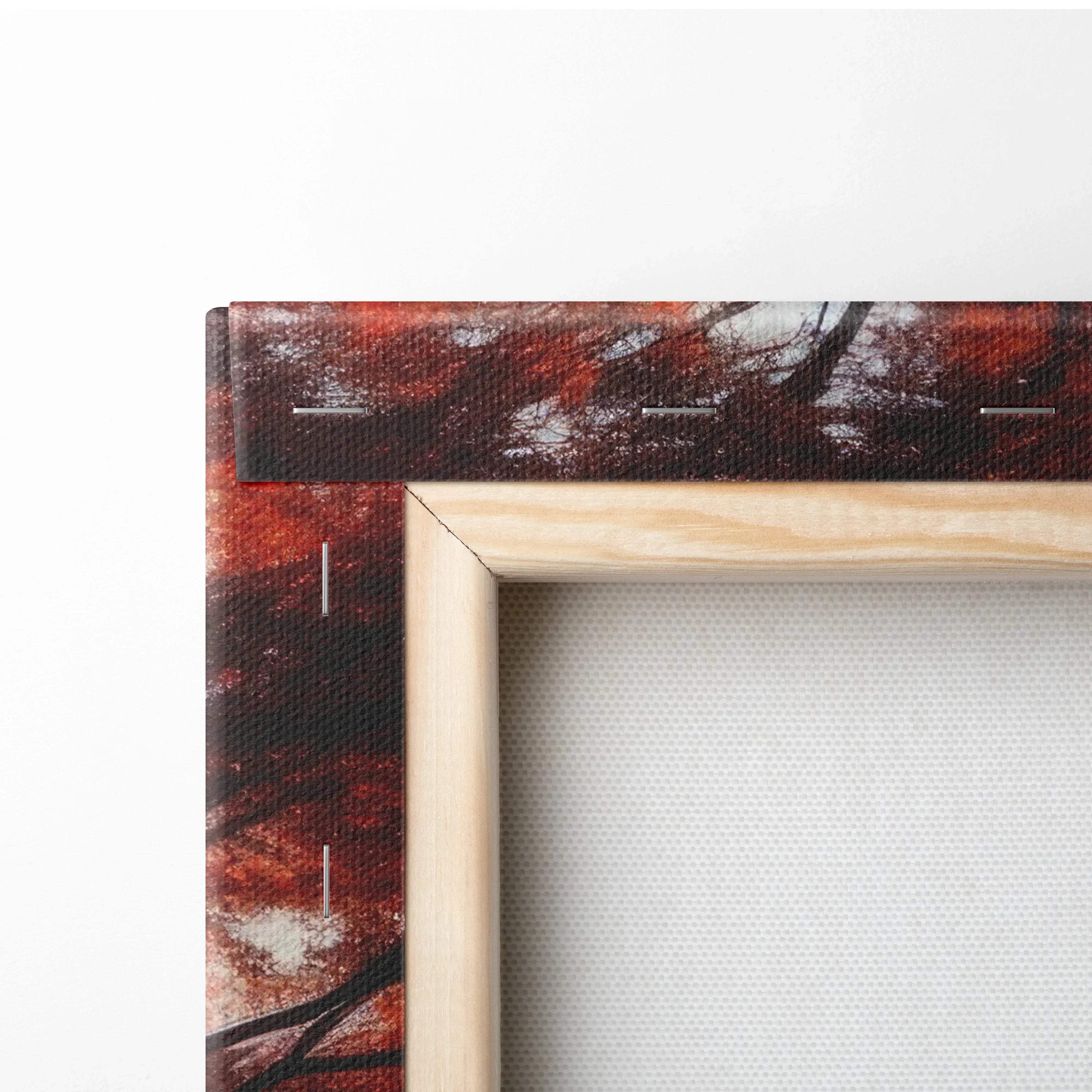 Close-up of wooden frame corner on autumn-themed canvas art with rich red and brown leaf details.