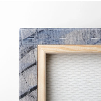 Close-up of corner of canvas wall art with winter scene, showing wooden frame and textured snow-covered landscape print.