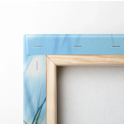 Close-up of corner-stretched canvas art with ocean blue print and natural wood frame edges.
