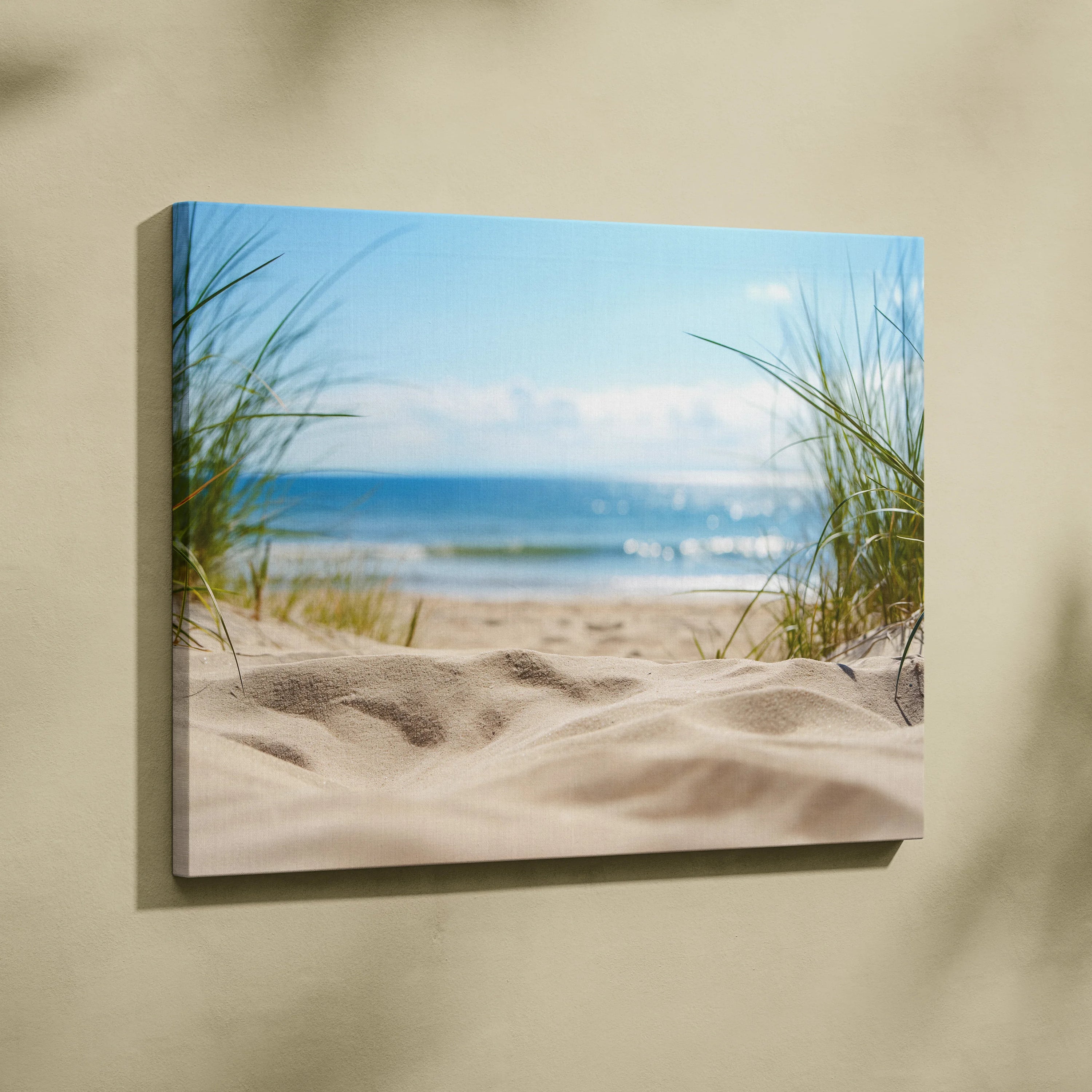 Canvas wall art featuring soft sandy dunes, green beach grass, and calm ocean waves under a blue sky with scattered clouds.