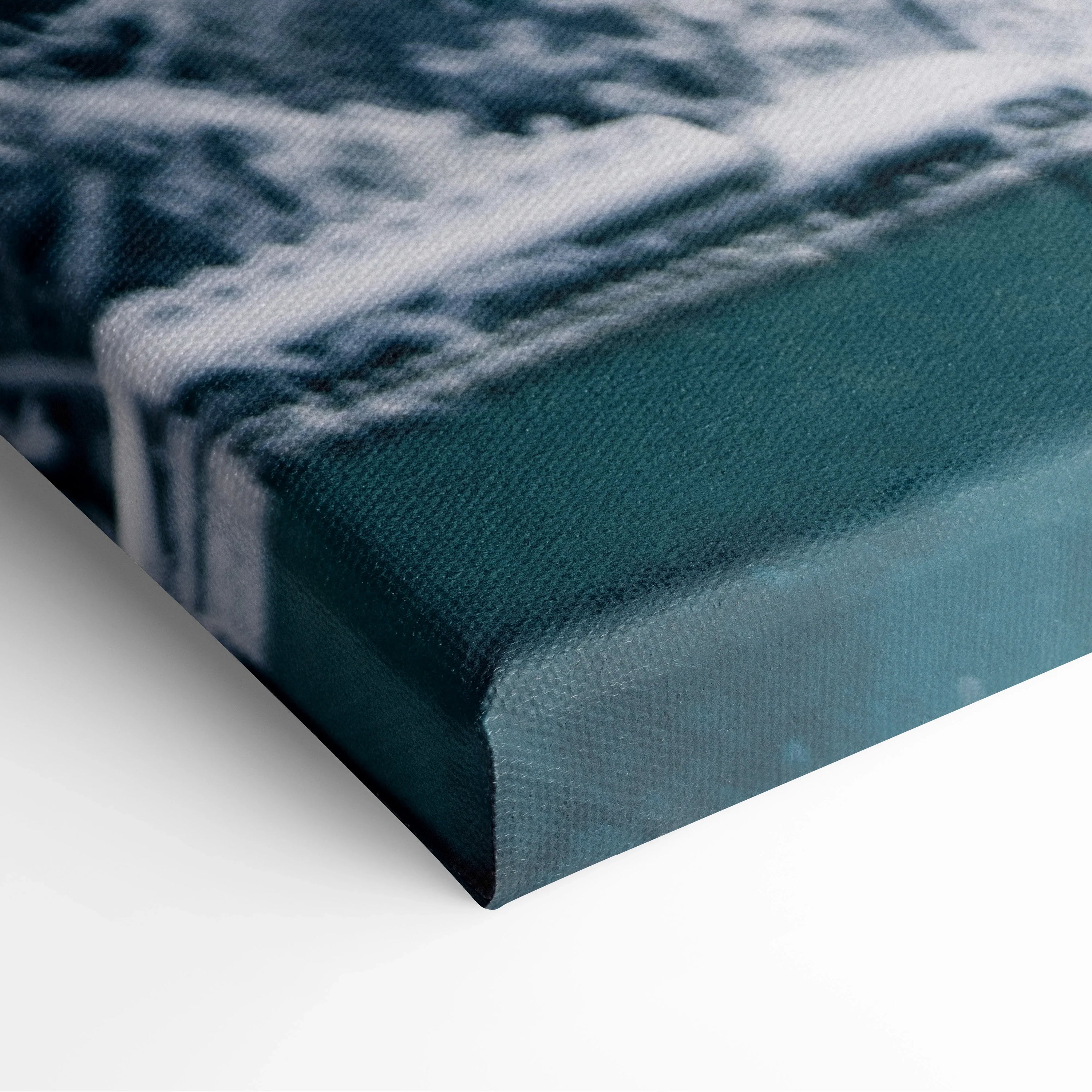 Close-up of canvas wall art corner featuring a snowy branch design with textured fabric and deep green background color.