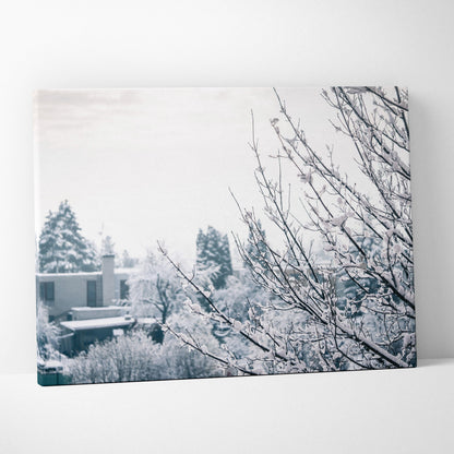 Canvas wall art featuring a snowy winter scene with bare branches covered in frost against a soft gray sky backdrop.