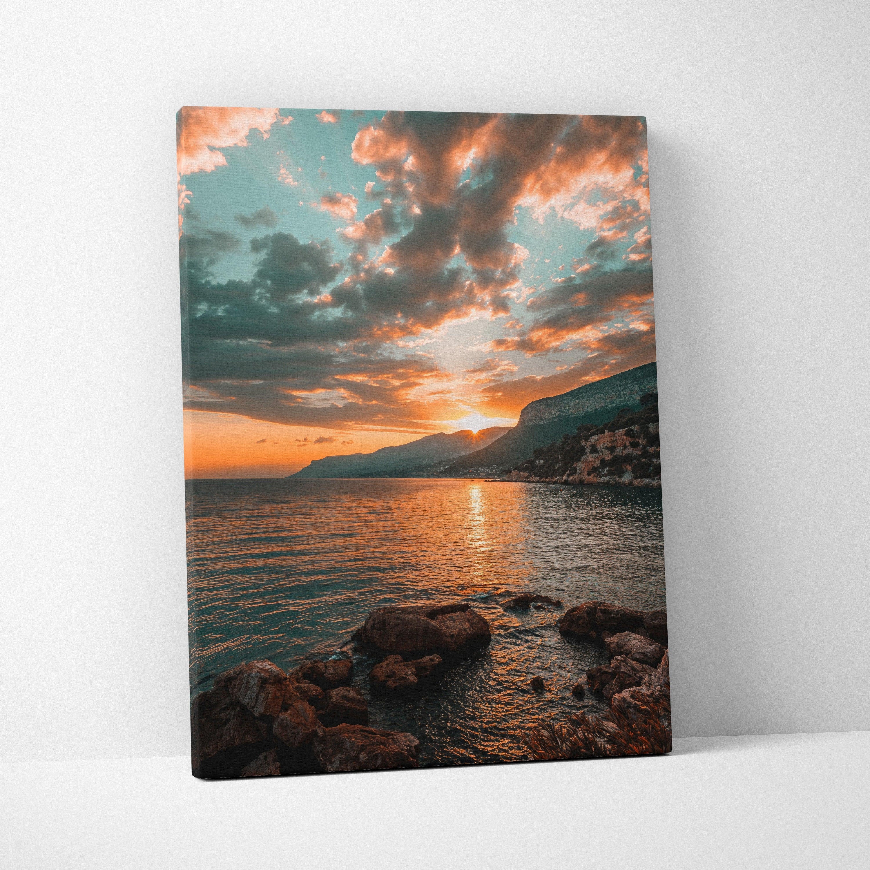 Sunset beach scene on canvas art with orange sky, clouds, calm water, and rocky shoreline.
