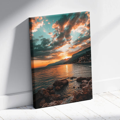 Sunset beach canvas art with rocky shoreline and vibrant orange and teal sky reflections on water.