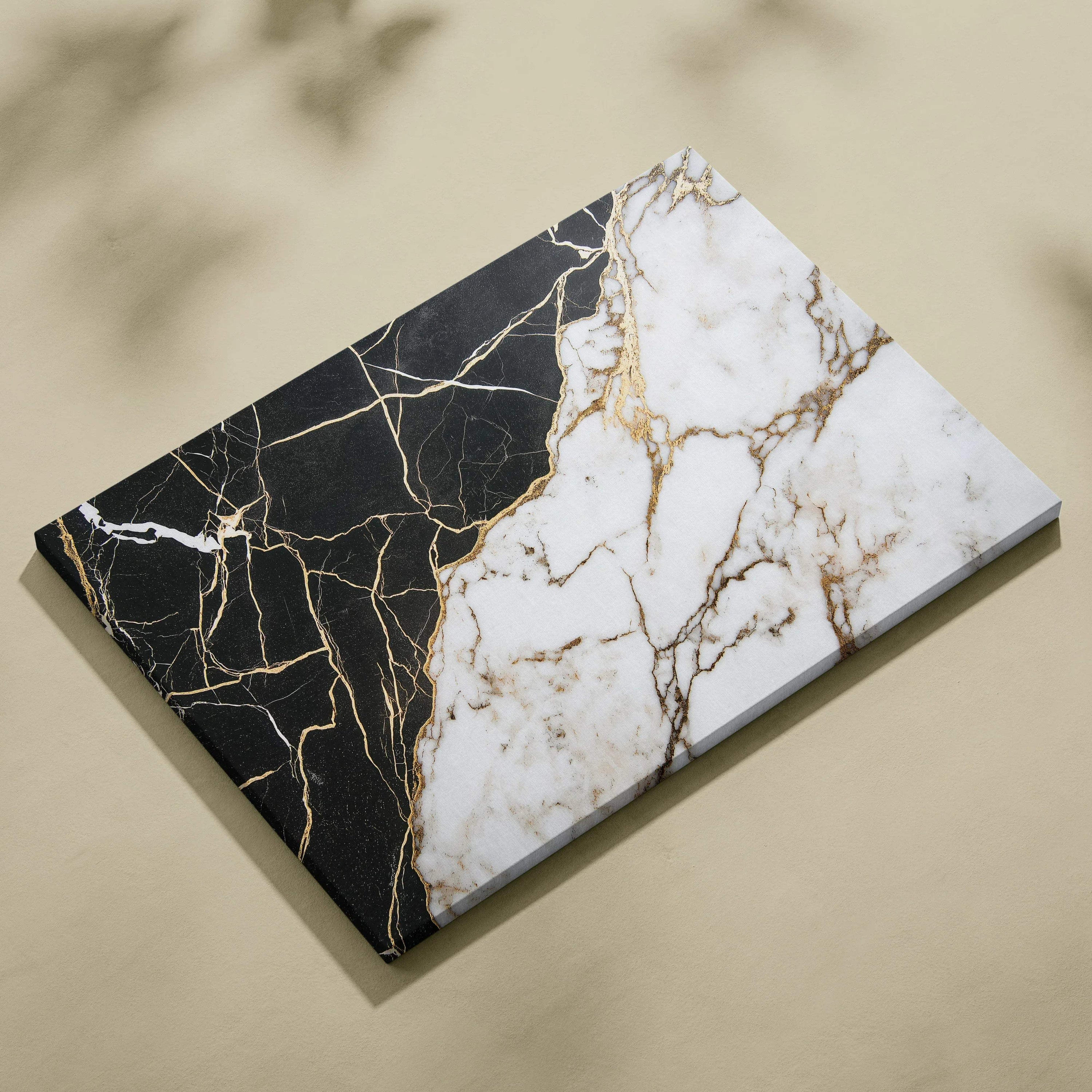 Abstract canvas art with black and white marble textures intersected by gold veins.