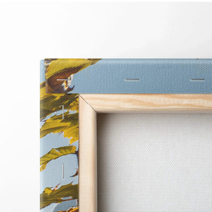 Close-up of canvas wall art corner with blue background, yellow floral design, and wooden stretcher frame.