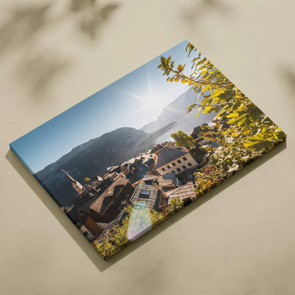 Canvas wall art featuring a sunlit mountain village with rooftops, church steeple, and greenery under a clear sky.