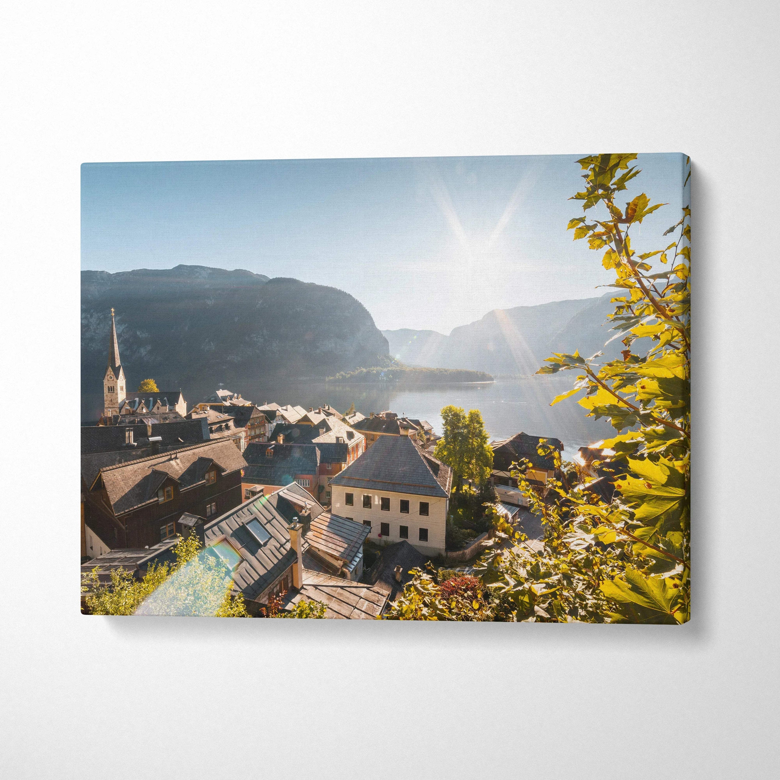 Canvas wall art featuring a sunlit mountain village with traditional buildings and foliage.