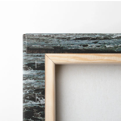 Close-up of wrapped canvas with natural wood frame showing textured fabric and blue-gray waterfall print on side for wall.