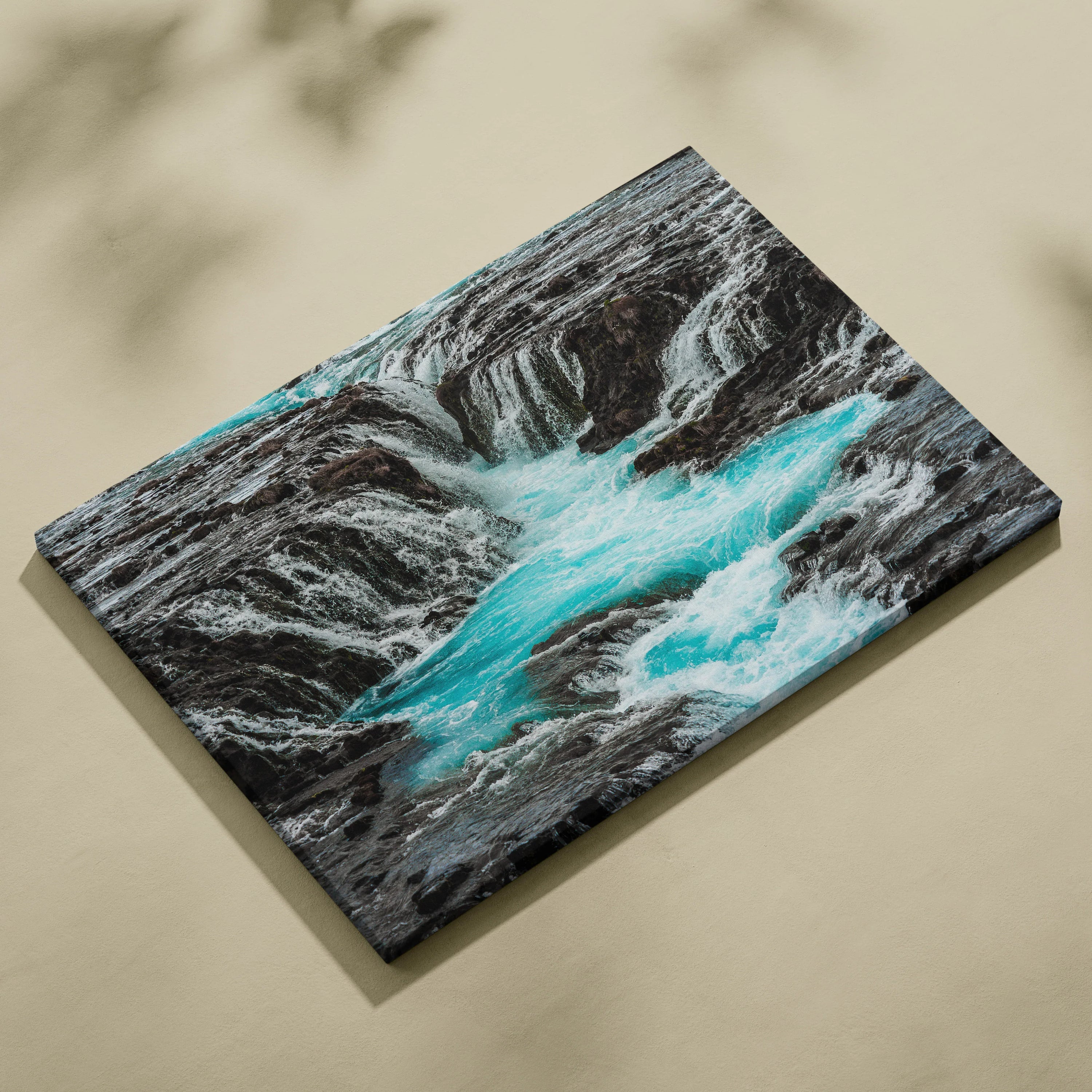 Canvas wall art featuring a turquoise waterfall cascading over dark rocky cliffs, nature-themed decor.
