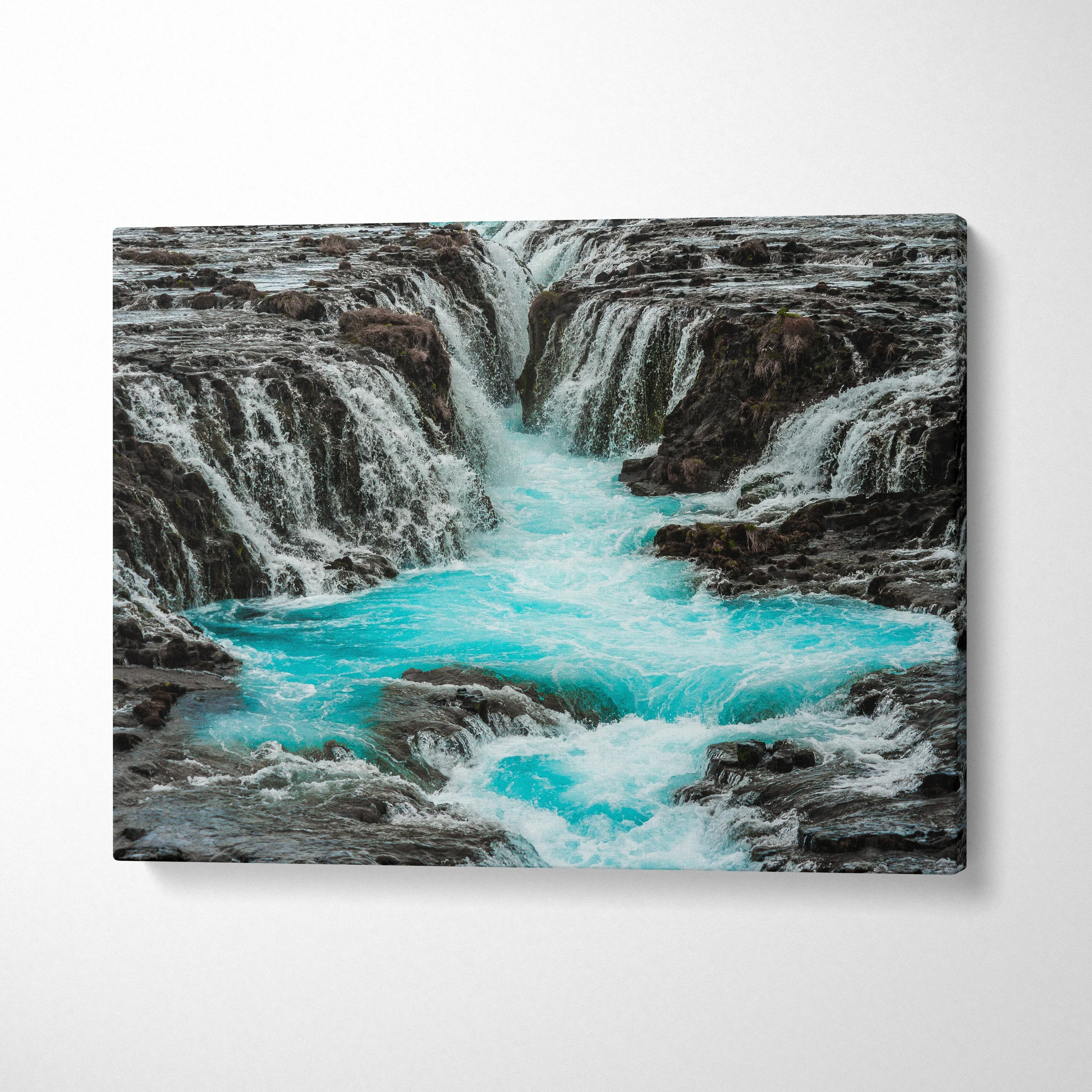 Canvas wall art featuring a turquoise Iceland waterfall flowing through rocky terrain, nature decor.