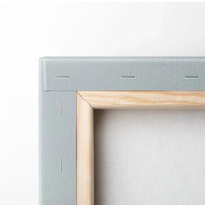 Close-up of canvas art corner with light wooden frame and gray fabric stretched over stretcher bars.