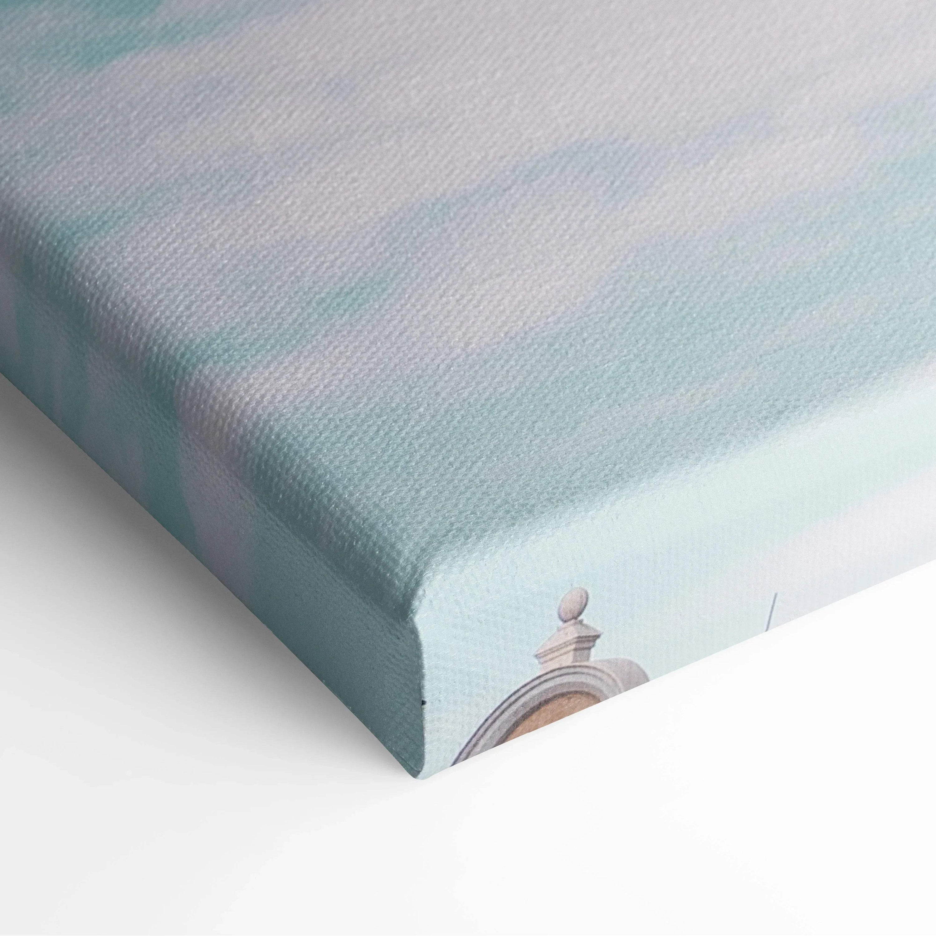 Close-up of canvas wall art with soft pastel blue and green tones, showing textured fabric and corner detail of.