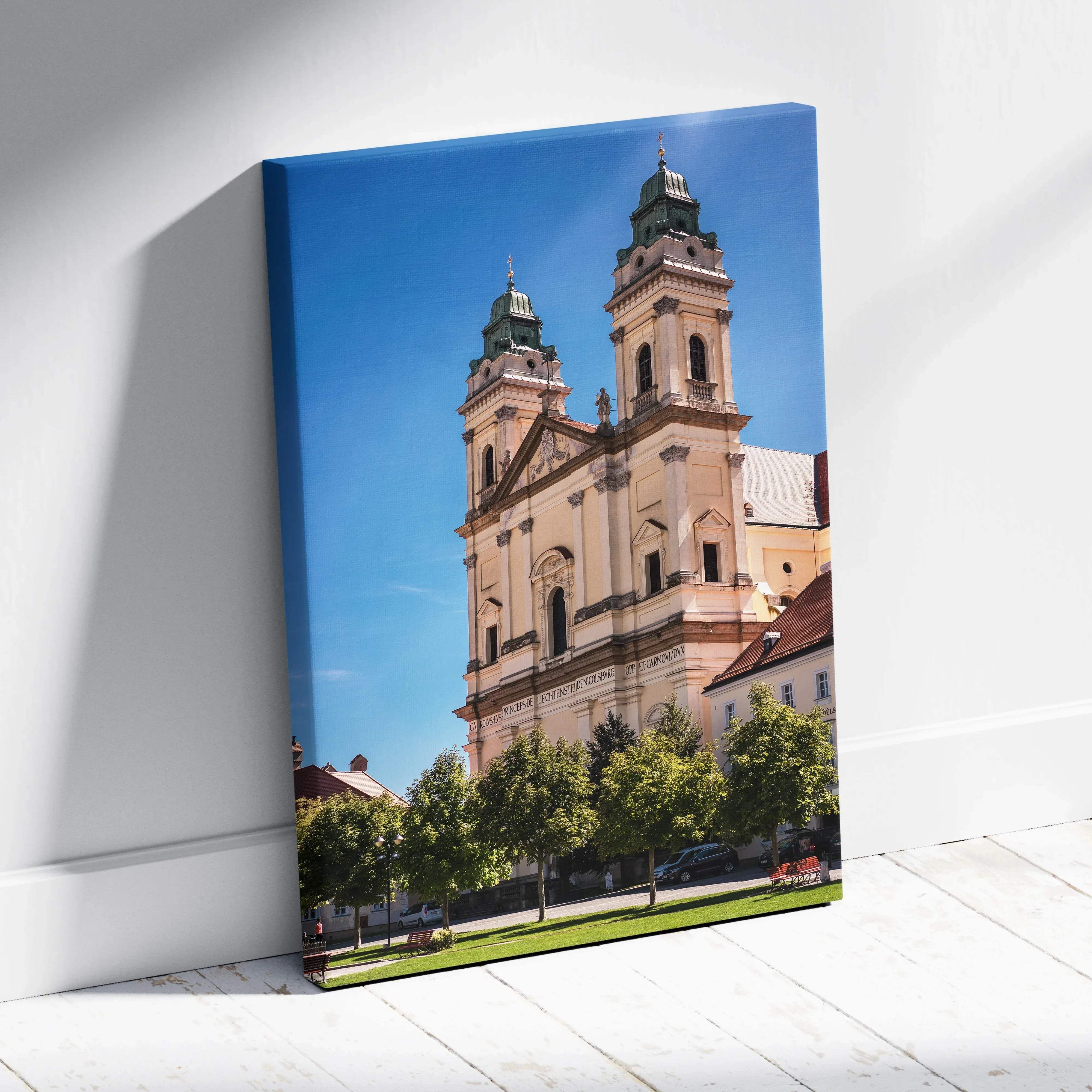 A framed canvas print of a historic church with twin green domes and beige stone facade under bright blue sky wall art