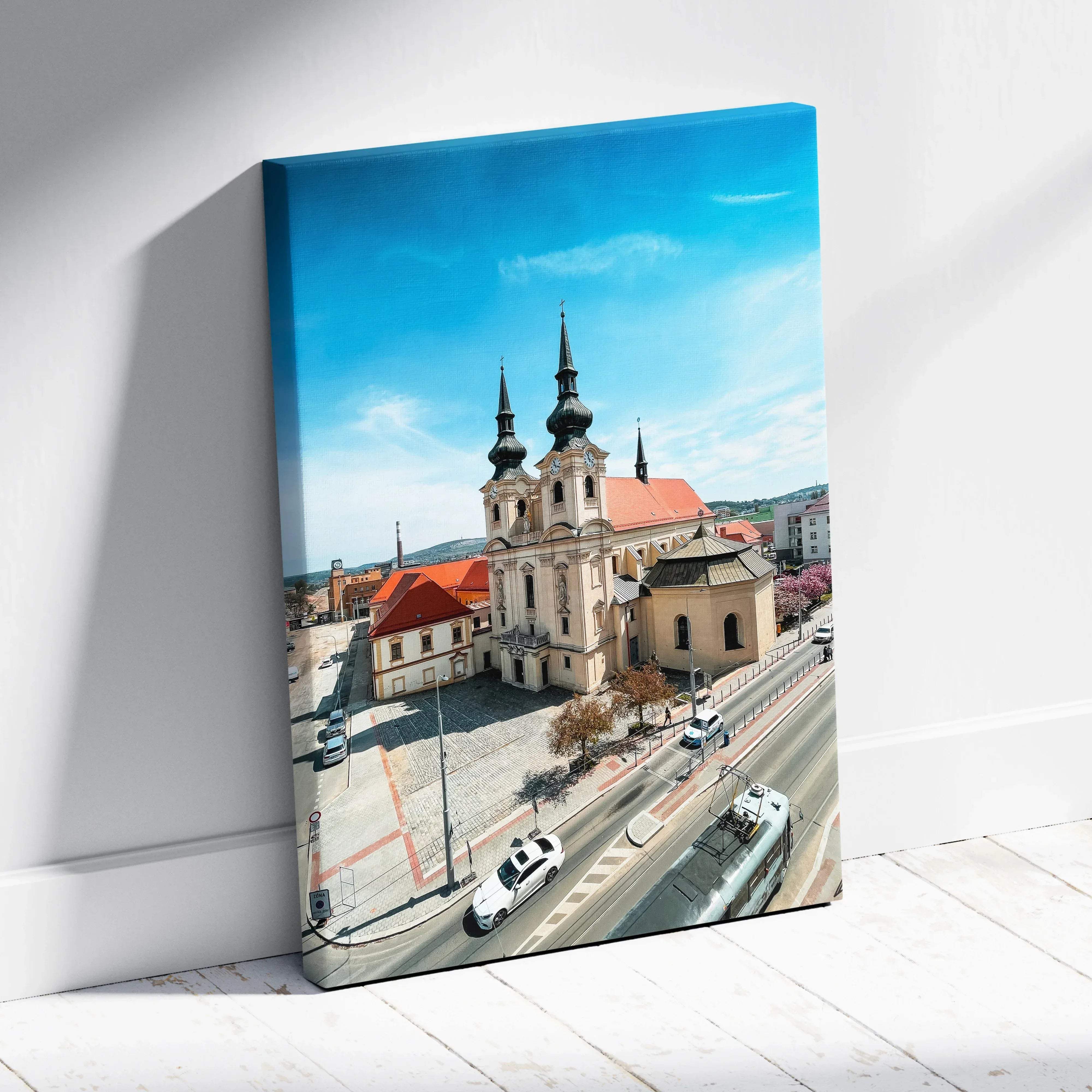 A vibrant canvas print of a historic church with twin spires and red-tiled roofs under a bright blue sky