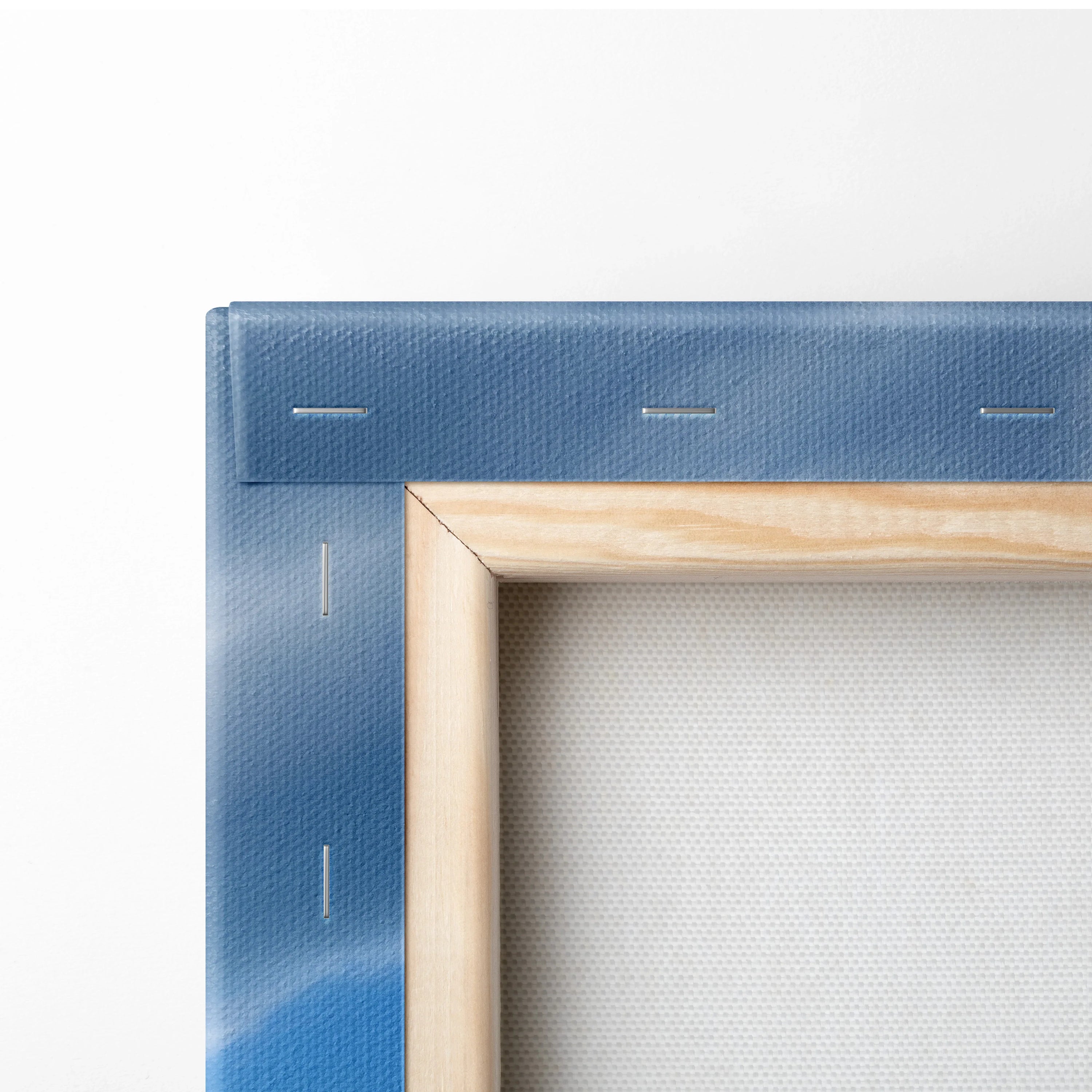 Close-up of blue canvas edge with wooden stretcher bars and tightly stretched fabric on wall art frame.