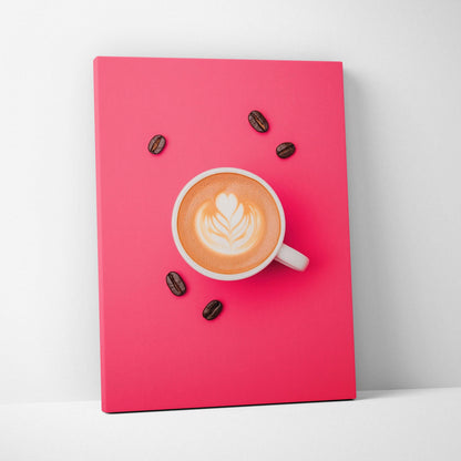 Canvas wall art featuring a white coffee cup with latte art and scattered coffee beans on a vibrant pink background.