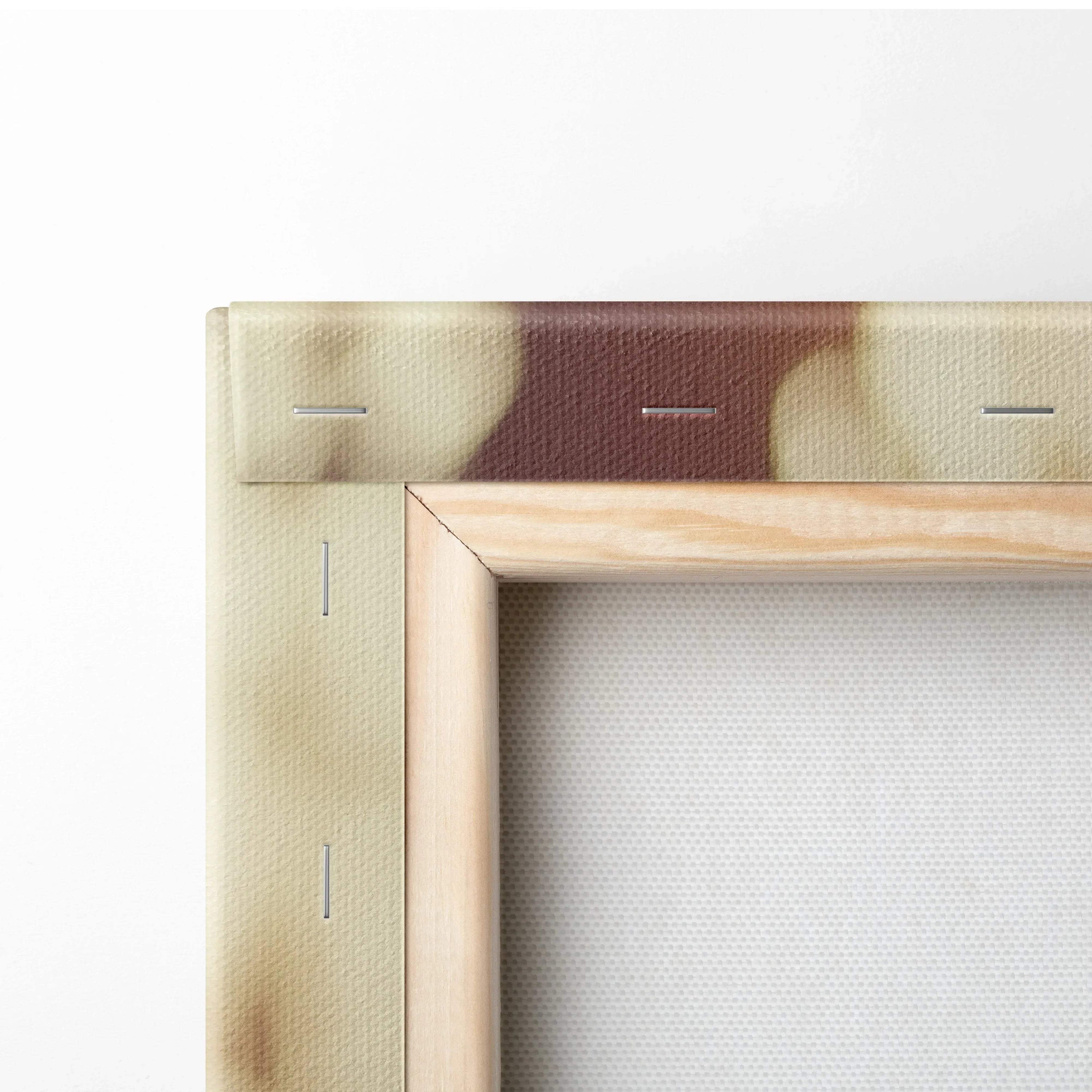 Close-up of wooden canvas frame with white fabric stretched and secured by staples on the back.
