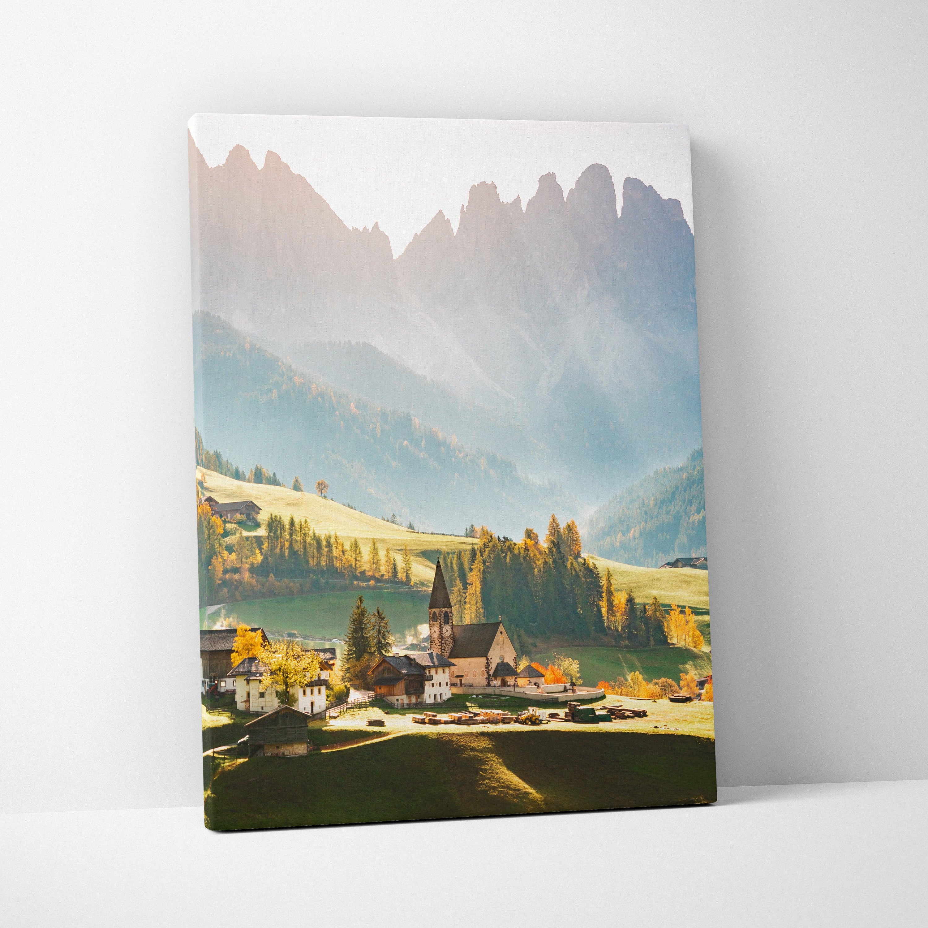 Canvas wall art featuring a serene village with a church and mountain peaks in soft morning light.