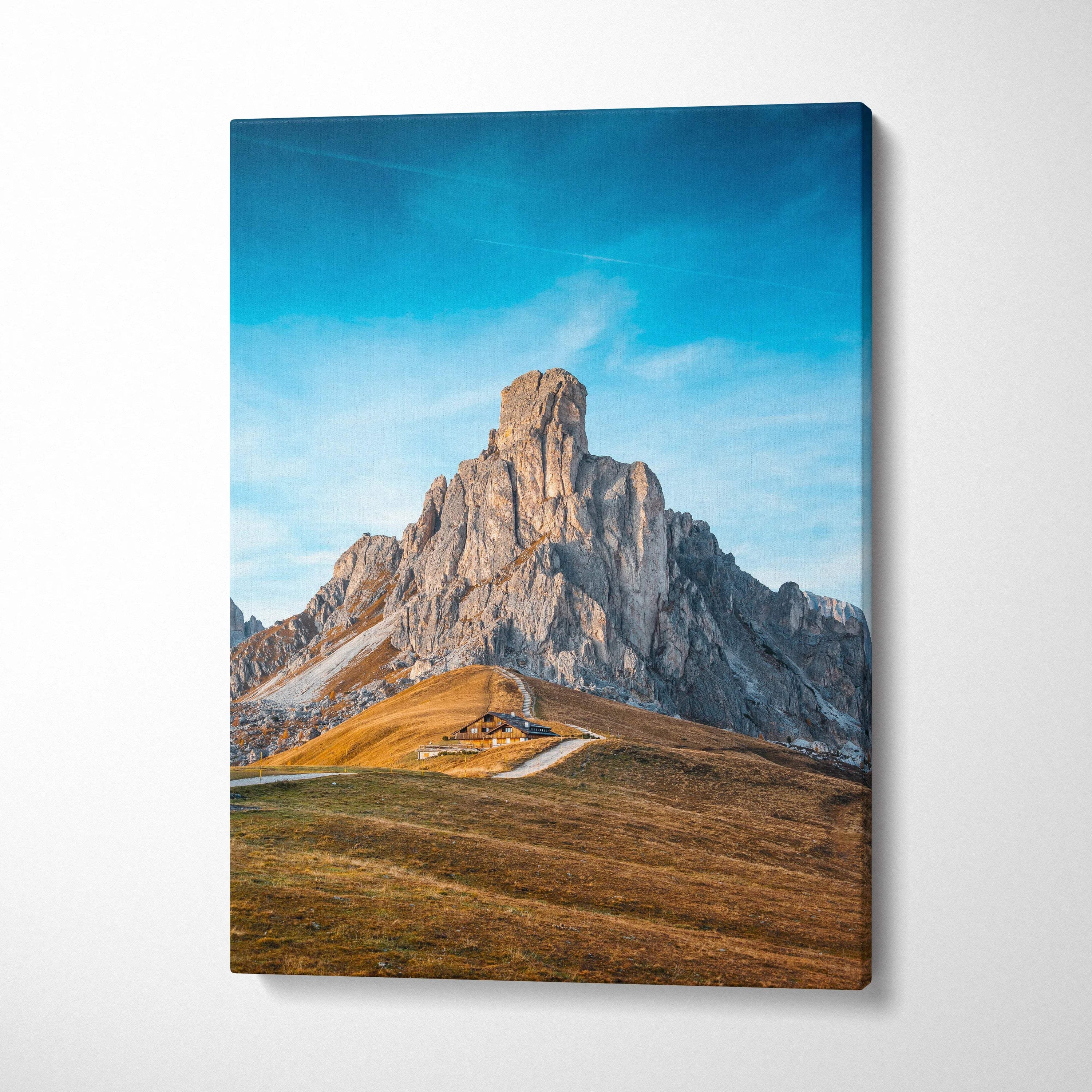 Canvas print of rugged Ra Gusela Peak over Giau Pass under serene blue sky