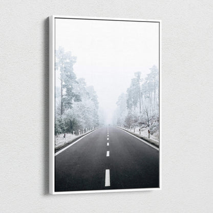 Canvas wall art depicting a snowy road flanked by frost-covered trees in a misty winter landscape.