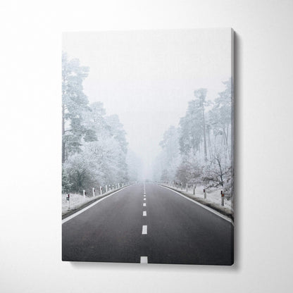 Vertical canvas wall art featuring a snowy road flanked by frosted trees in a serene winter landscape decor piece.