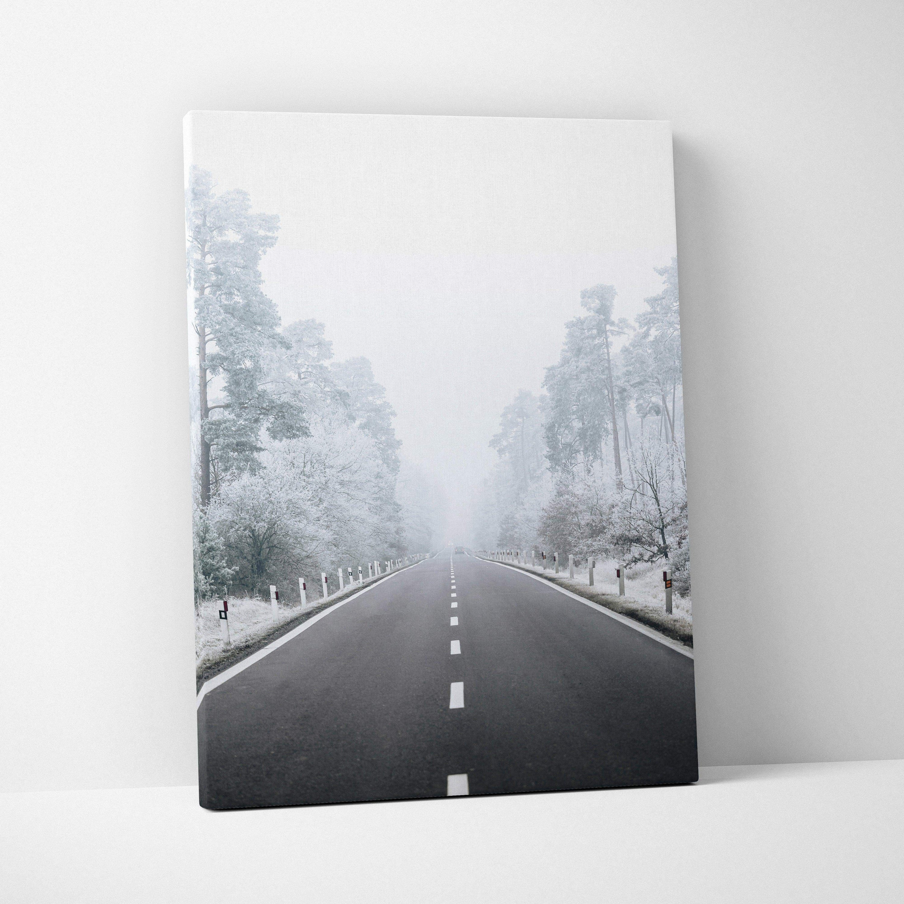 Canvas wall art featuring a snowy road flanked by frosted trees in a serene winter landscape.