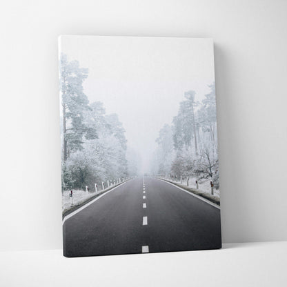 Canvas wall art featuring a snowy road flanked by frosted trees in a serene winter landscape.
