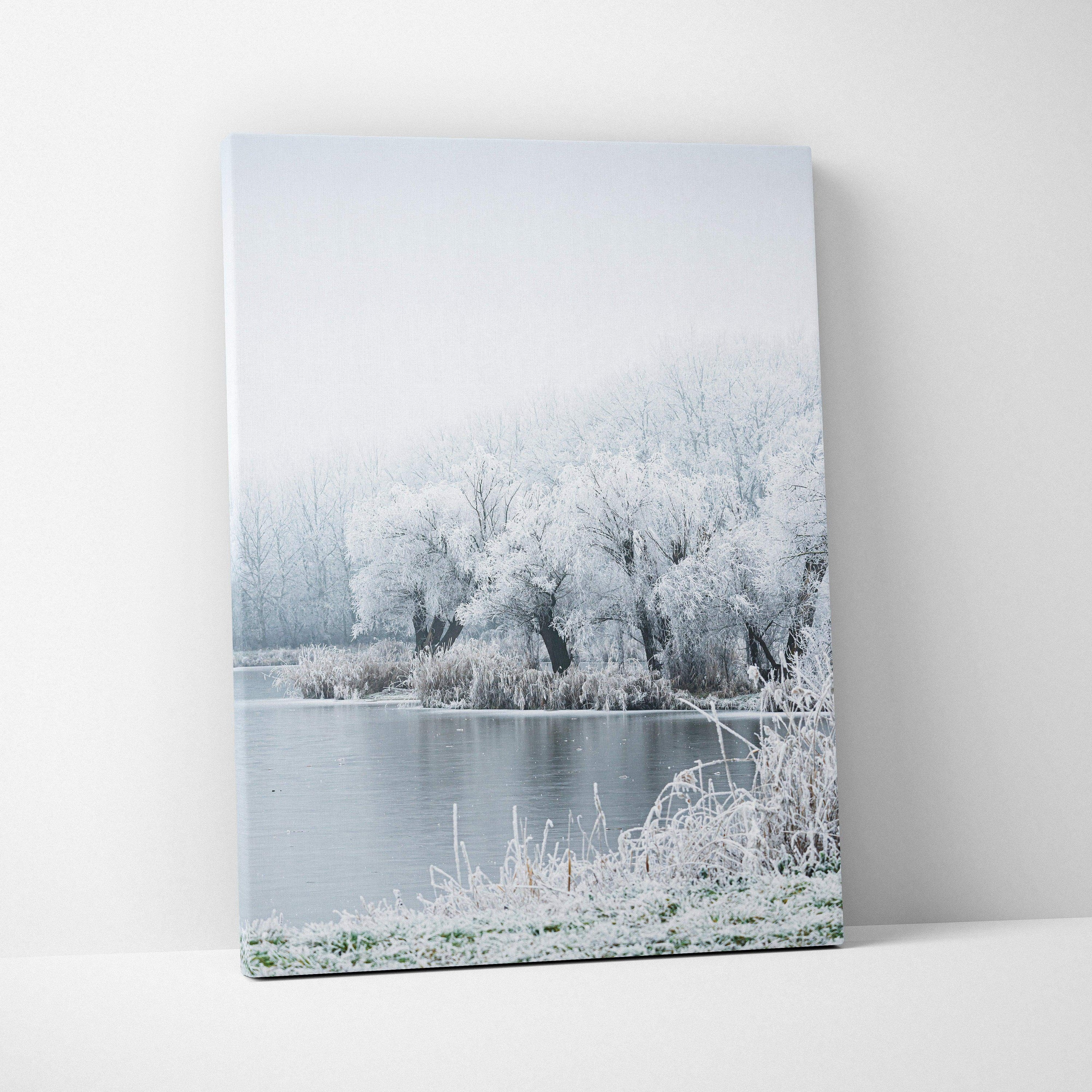 Winter landscape canvas wall art featuring snowy trees by a calm river for home decor.