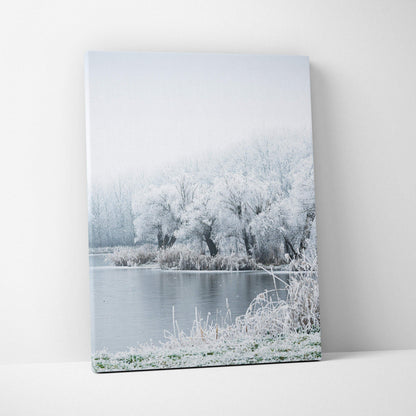 Winter landscape canvas wall art featuring snowy trees by a calm river for home decor.
