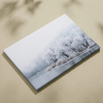Canvas wall art print featuring snowy trees in soft grayscale tones with a misty winter landscape backdrop.