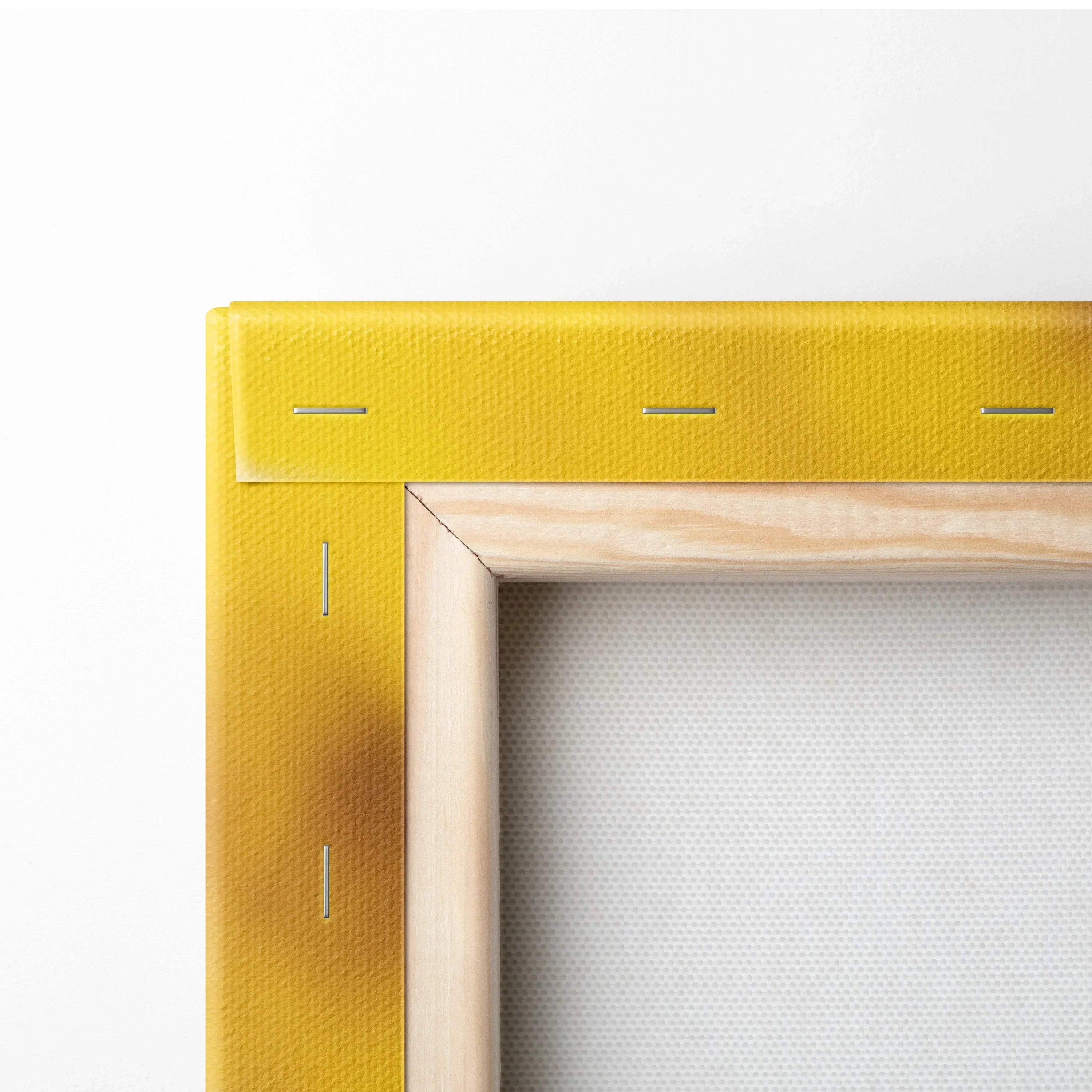 Close-up of wooden frame and yellow stretcher bar on canvas wall art decor with visible staples and textured fabric.
