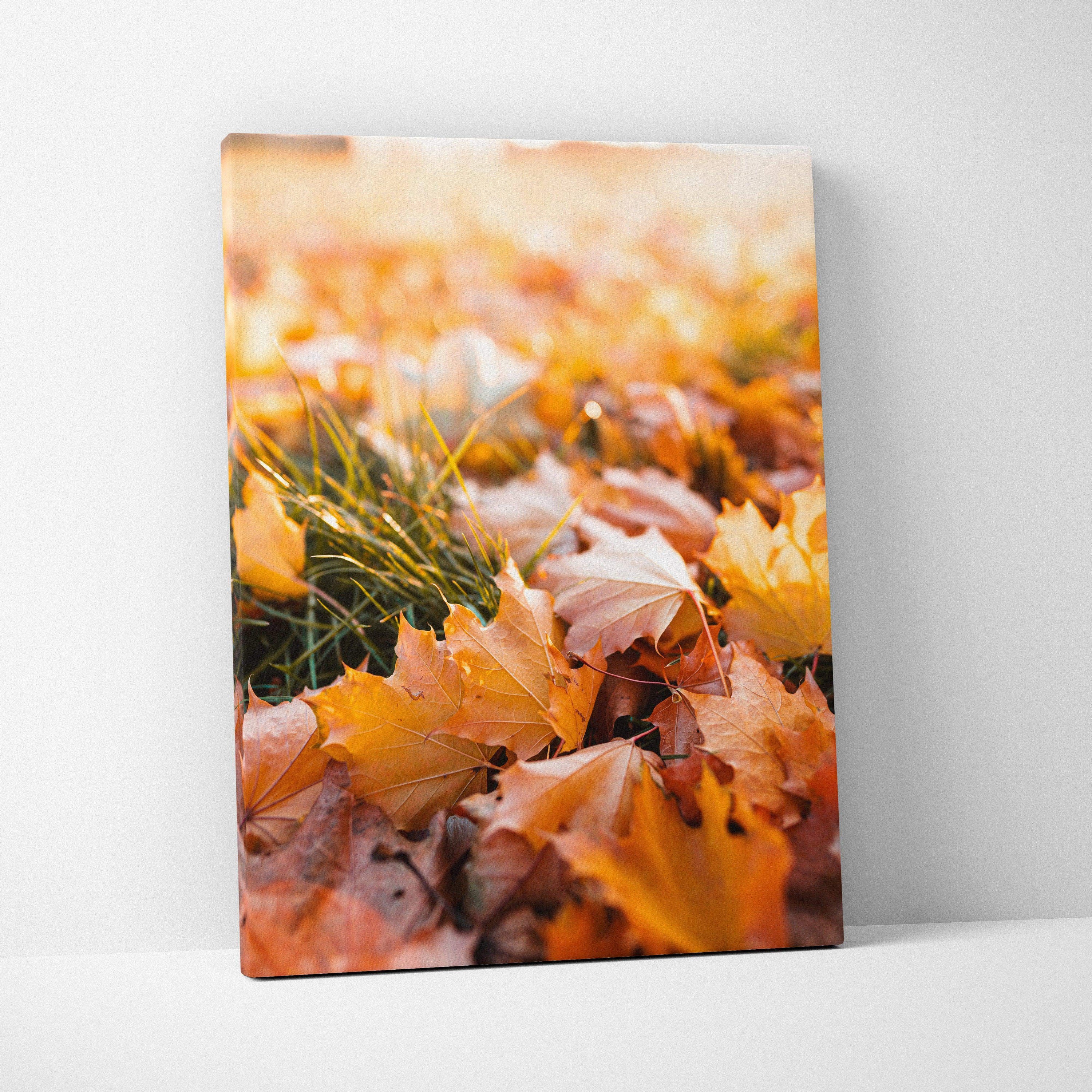 Vertical canvas wall art featuring vibrant autumn leaves and grass in warm tones.