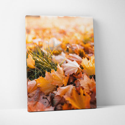 Vertical canvas wall art featuring vibrant autumn leaves and grass in warm tones.