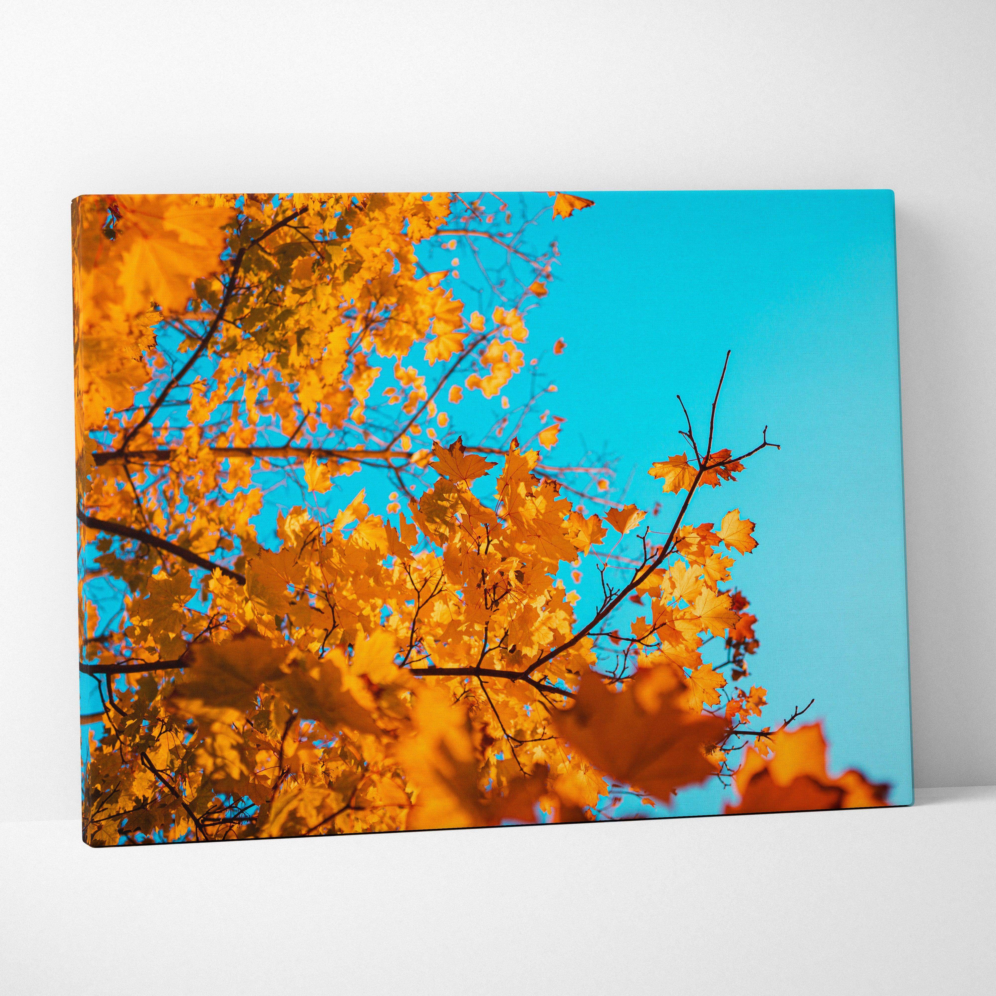 A vibrant canvas wall art featuring golden autumn leaves against a bright blue sky for home decor