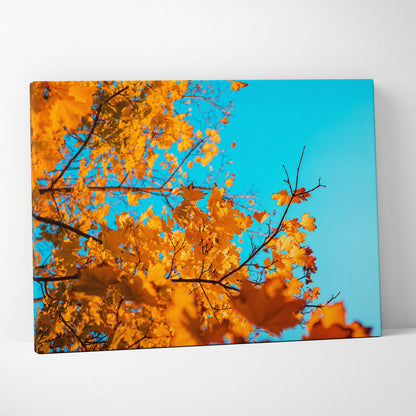 Canvas wall art featuring golden autumn leaves against a bright blue sky in warm fall colors.