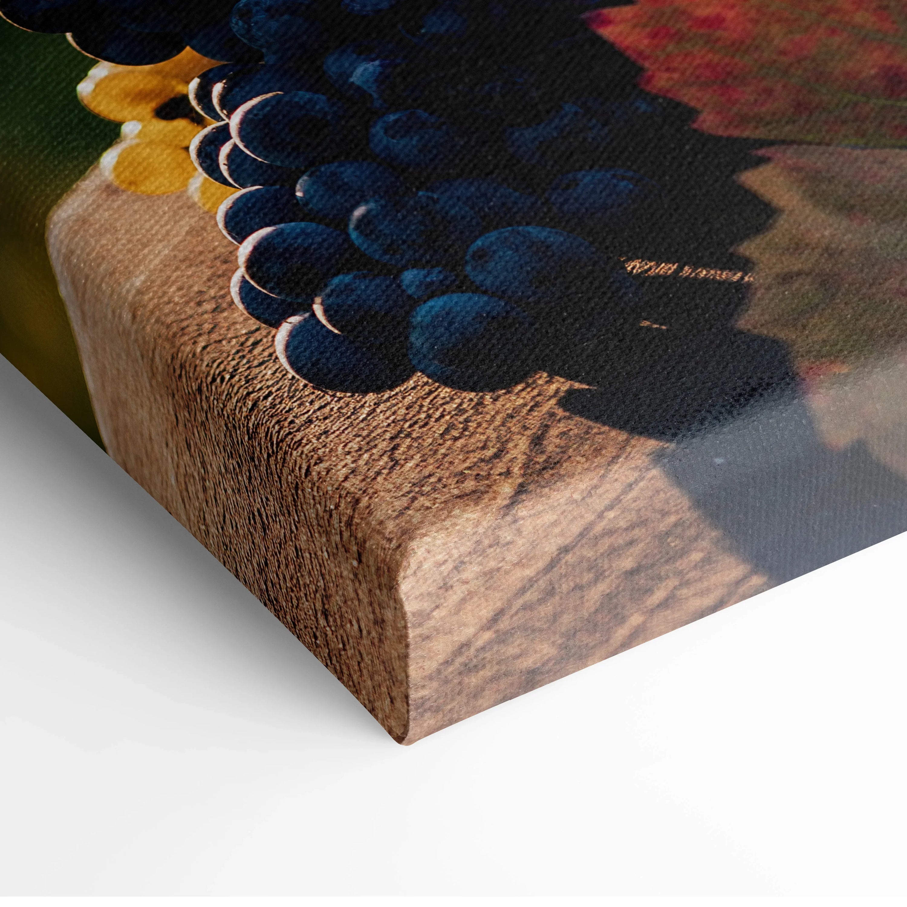 Canvas wall art featuring vibrant clusters of blue and yellow grapes on a wooden table surface.