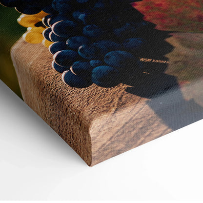 Canvas wall art featuring vibrant clusters of blue and yellow grapes on a wooden table surface.