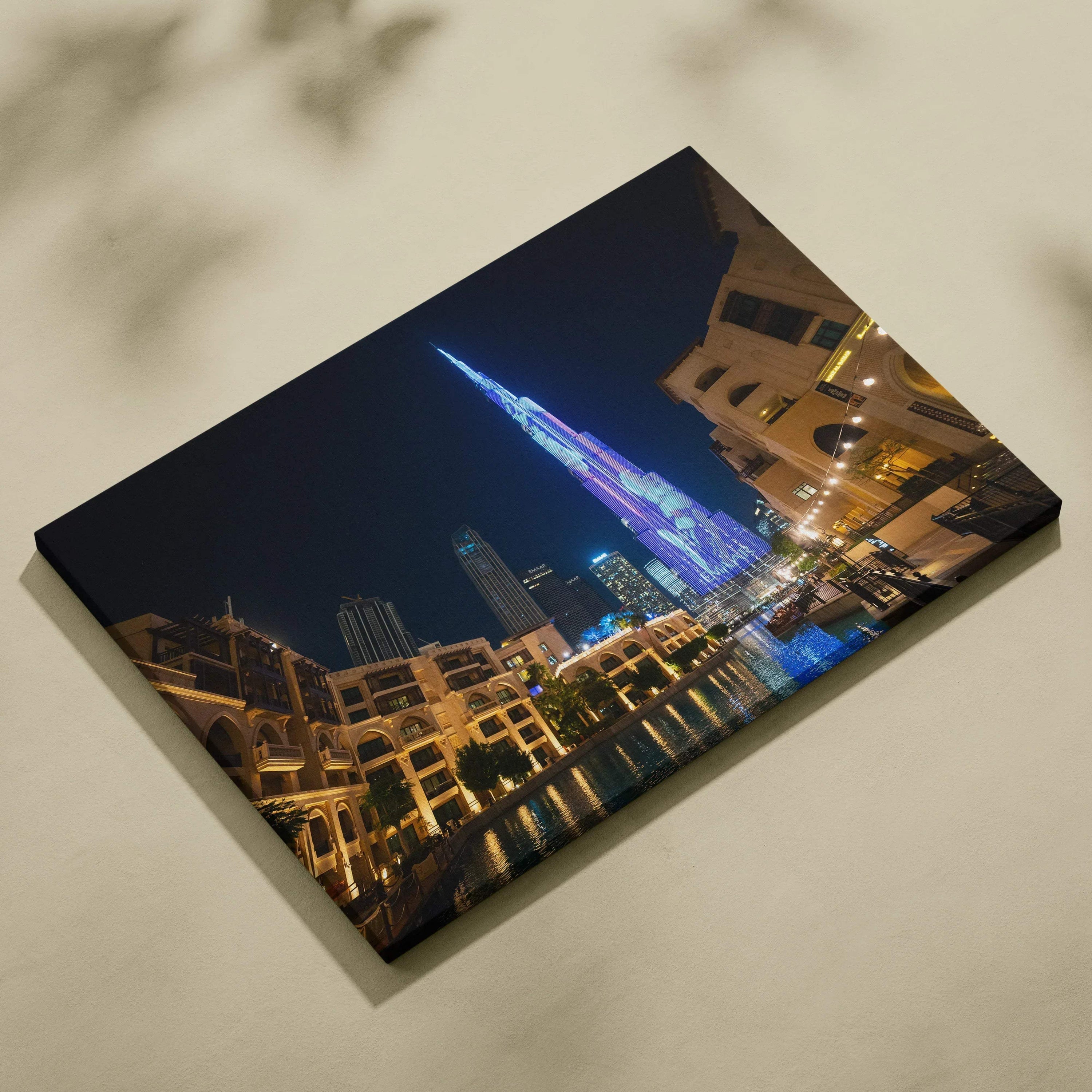 Nighttime cityscape canvas art featuring illuminated modern skyscraper with reflections on water.
