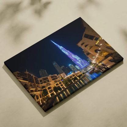 Nighttime cityscape canvas art featuring illuminated modern skyscraper with reflections on water.