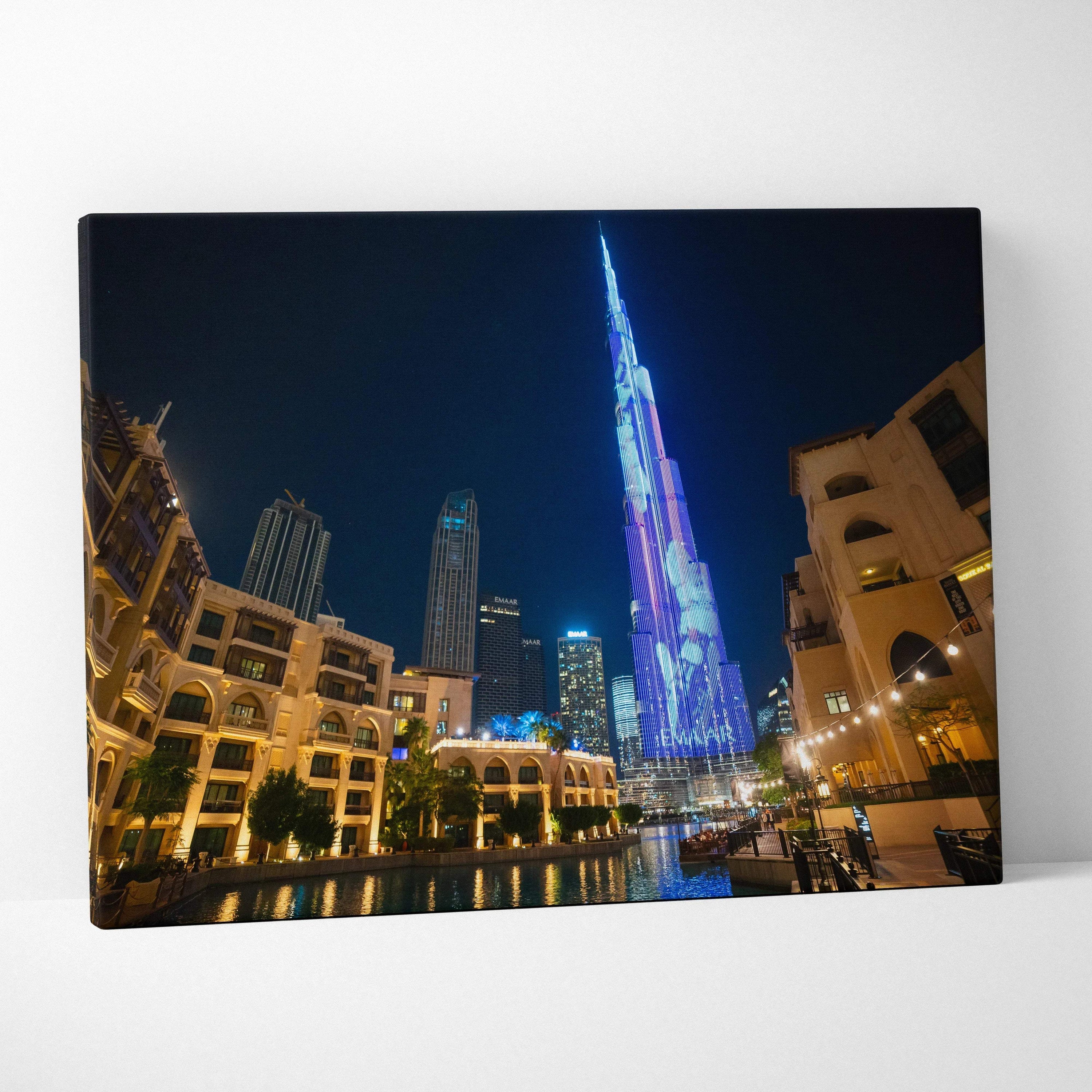Canvas wall art featuring a vibrant nighttime cityscape with illuminated skyscrapers and reflections on water.