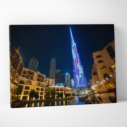 Canvas wall art featuring a vibrant nighttime cityscape with illuminated skyscrapers and reflections on water.